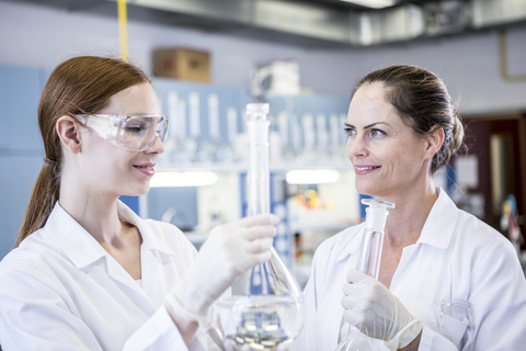Two smiling scientists working together in lab stock photo
