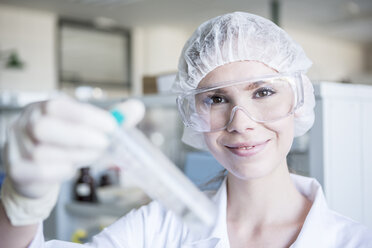 Porträt eines lächelnden Wissenschaftlers im Labor mit Reagenzglas - WESTF23737