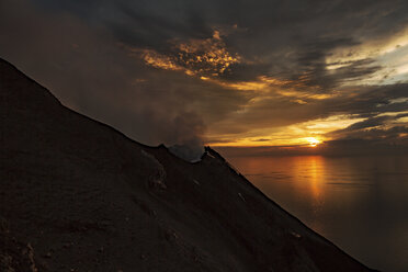 Italy, Aeolian Islands, Stromboli, volcanic eruption facing sunset - THGF00031