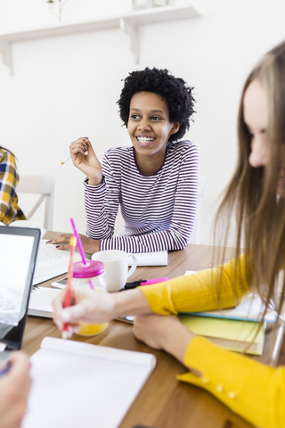 Group of female students working together at table at home stock photo