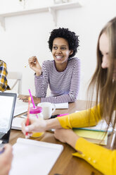 Gruppe von Studentinnen, die zu Hause am Tisch zusammenarbeiten - GIOF03373