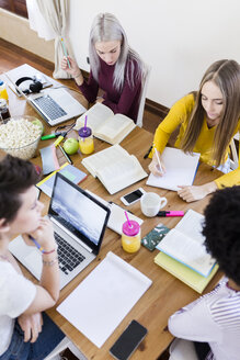 Gruppe von Studentinnen, die zu Hause am Tisch zusammenarbeiten - GIOF03375