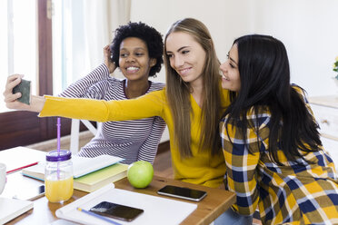 Gruppe von Studentinnen, die ein Selfie am Tisch zu Hause machen - GIOF03379