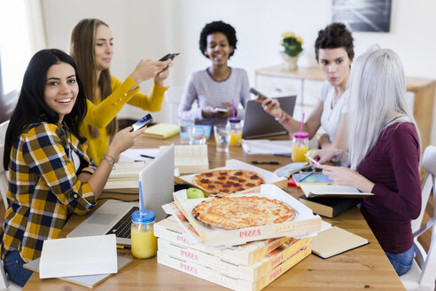 Gruppe junger Frauen, die zu Hause lernen und Pizza essen - GIOF03393