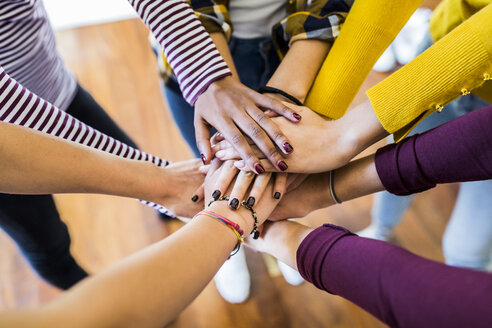 Close-up of five women stacking their hands - GIOF03419