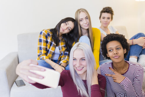 Glückliche Freundinnen machen ein Selfie im Wohnzimmer - GIOF03425
