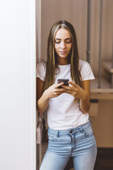 Young woman at home using cell phone - GIOF03462