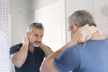 Mature man looking in bathroom mirror - ALBF00270