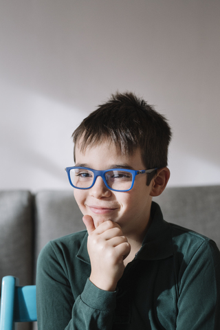 Porträt eines lächelnden Jungen mit blauer Brille, lizenzfreies Stockfoto