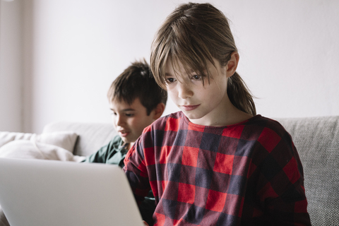 Mädchen im Wohnzimmer mit Laptop, lizenzfreies Stockfoto