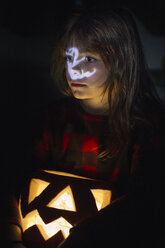 Portrait of girl with lighted Jack O'Lantern at Halloween - ALBF00314