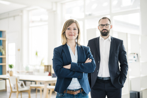 Portrait of confident businesswoman and man in office stock photo
