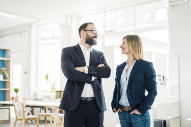 Smiling businesswoman and businessman in office - JOSF01920