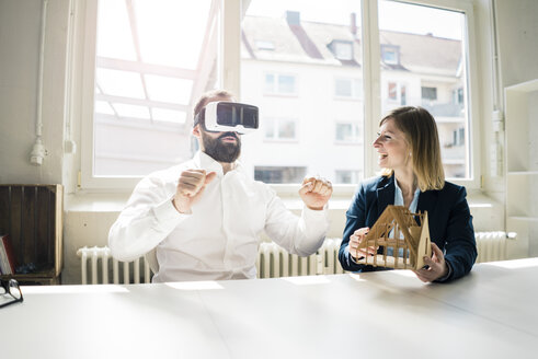 Frau und Mann mit Hausmodell und VR-Brille im Büro - JOSF01933