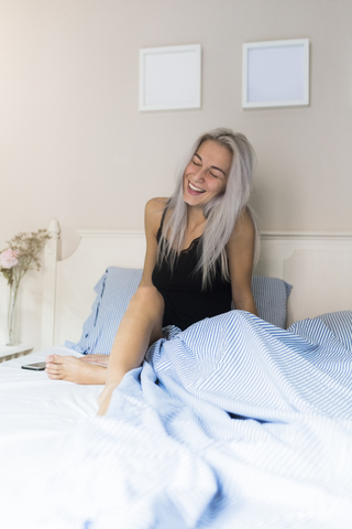 Glückliche junge Frau im Bett, lizenzfreies Stockfoto