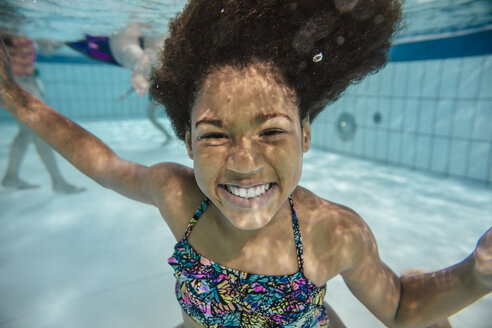 Porträt eines lächelnden Mädchens unter Wasser im Schwimmbad - MFF04166