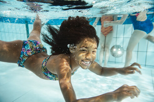 Porträt eines lächelnden Mädchens unter Wasser im Schwimmbad - MFF04174