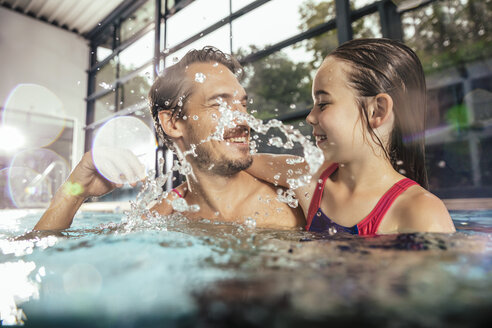 Glücklicher Vater mit Tochter beim Planschen im Hallenbad - MFF04197