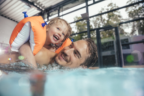 Happy father with daughter in indoor swimming pool stock photo