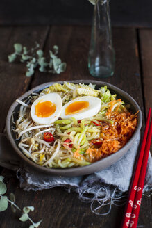 Schüssel mit glutenfreier Udon-Nudelsuppe mit Karotten, Chinakohl, Zoodles, Mungobohnensprossen und gekochtem Ei - SBDF03384