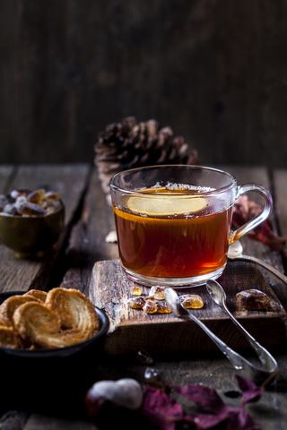 Glass of black tea with slice of lemon and rock sugar on wooden table stock photo