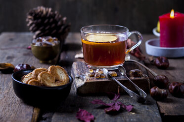 Glas schwarzer Tee mit Zitronenscheibe und Kandiszucker auf Holztisch - SBDF03387