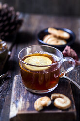 Glas schwarzer Tee mit Zitronenscheibe und Kandiszucker auf Holztisch - SBDF03388