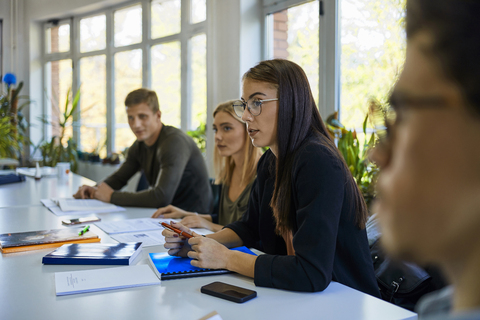 Studenten sitzen an einem Tisch in der Universität, lizenzfreies Stockfoto