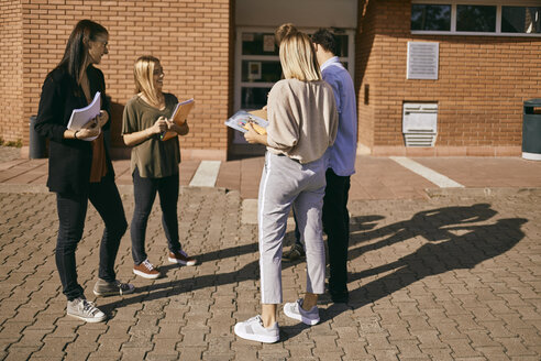 Gruppe von Studenten, die mit Dokumenten im Freien stehen - ZEDF00998