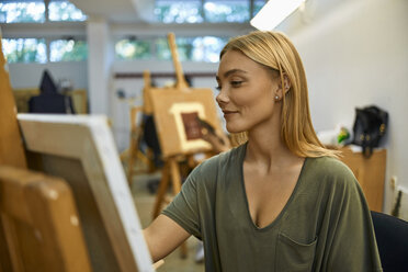Lächelnde Schülerin malt auf der Staffelei im Kunstunterricht - ZEDF01011