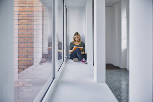 Student sitting at the window in hallway learning - ZEDF01026