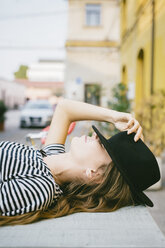 Young woman covering eyes with her hat - GIOF03544