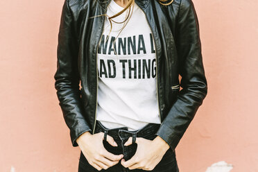 Fashionable young woman wearing printed t-shirt and leather jacket, partial view - GIOF03553