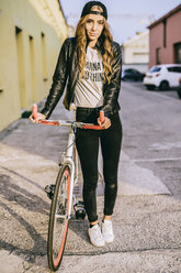 Porträt einer modischen jungen Frau mit Fahrrad - GIOF03554