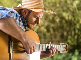 Mann spielt Gitarre in der Natur - STSF01435