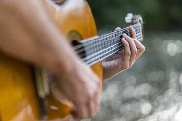 Mann spielt Gitarre in der Natur, Nahaufnahme - STSF01438