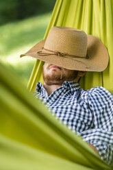 Mann entspannt in Hängematte mit Hut auf dem Gesicht - STSF01440