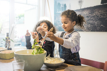 Glückliche Familie isst Spaghetti, Mädchen serviert Salat - MOEF00314