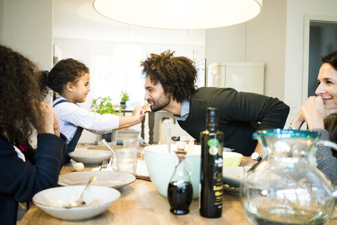 Glückliche Familie beim gemeinsamen Essen von Pizza und Pasta - MOEF00341