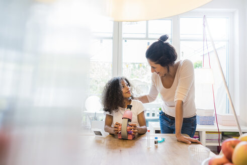 Mother helping daughter with homework, using microscope - MOEF00384