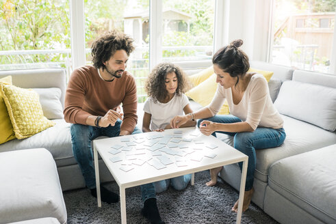 Familie sitzt auf der Couch und spielt ein Memory-Spiel - MOEF00388