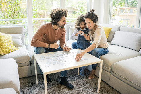 Familie sitzt auf der Couch und spielt ein Memory-Spiel - MOEF00389