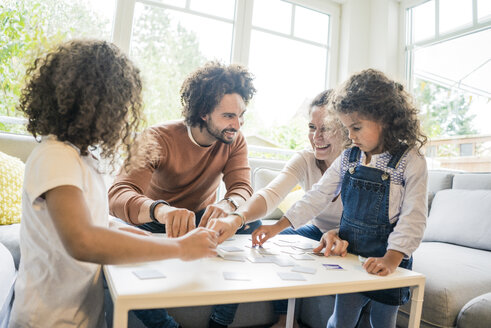 Family sitting on couch , playing memory game - MOEF00392