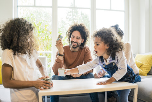 Familie sitzt auf der Couch und spielt ein Memory-Spiel - MOEF00394