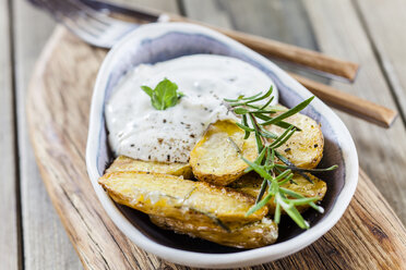 Bowl of potato wedges with rosemary and herbed curd cheese - SBDF03390