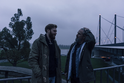 Vater und Sohn treffen sich auf der Brücke und besprechen Geschäfte, lizenzfreies Stockfoto