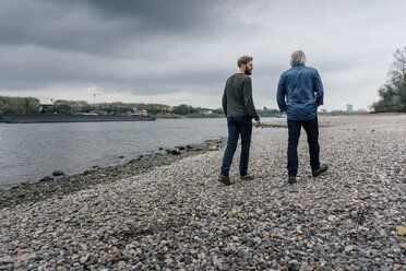 Vater und Sohn machen einen Spaziergang am Rhein und treffen sich zum Gespräch - KNSF02905