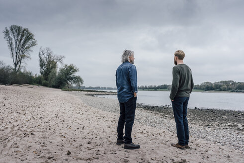 Vater und Sohn machen einen Spaziergang am Rhein und treffen sich zum Gespräch - KNSF02912