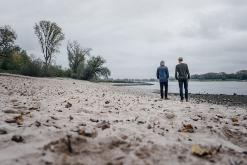 Vater und Sohn machen einen Spaziergang am Rhein und treffen sich zum Gespräch - KNSF02913
