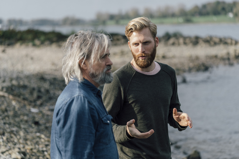 Father and son meeting outdoors, talking together stock photo